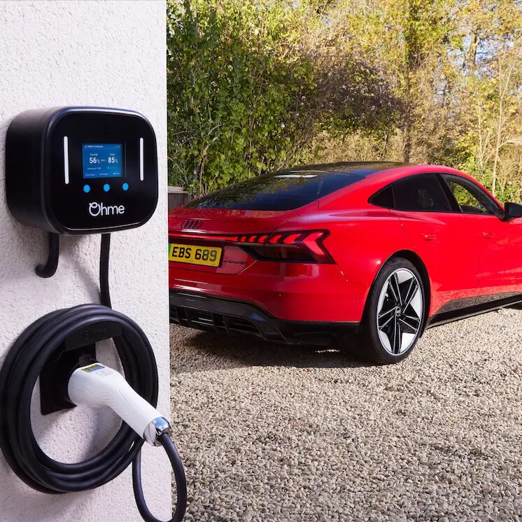 Lookers Audi Make the Switch Content Image featuring a red Audi E-Tron GT at home next to ohme Wall Box Charger.