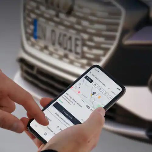 Close up shot of person using the myAudi app to charge their Audi e-tron remotely. 