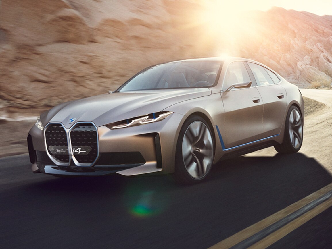 These are the electric cars with the longest range blog image featuring the electric BMW i4 in gold driving