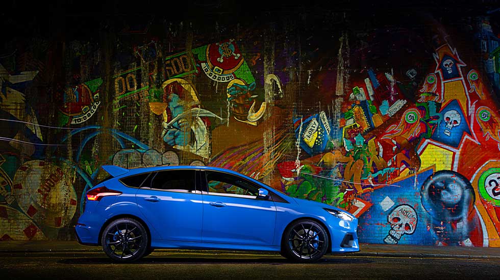 Used Ford Focus RS Header Image featuring a side on shot of a blue second hand Ford  Focus RS parked in front of graffiti.