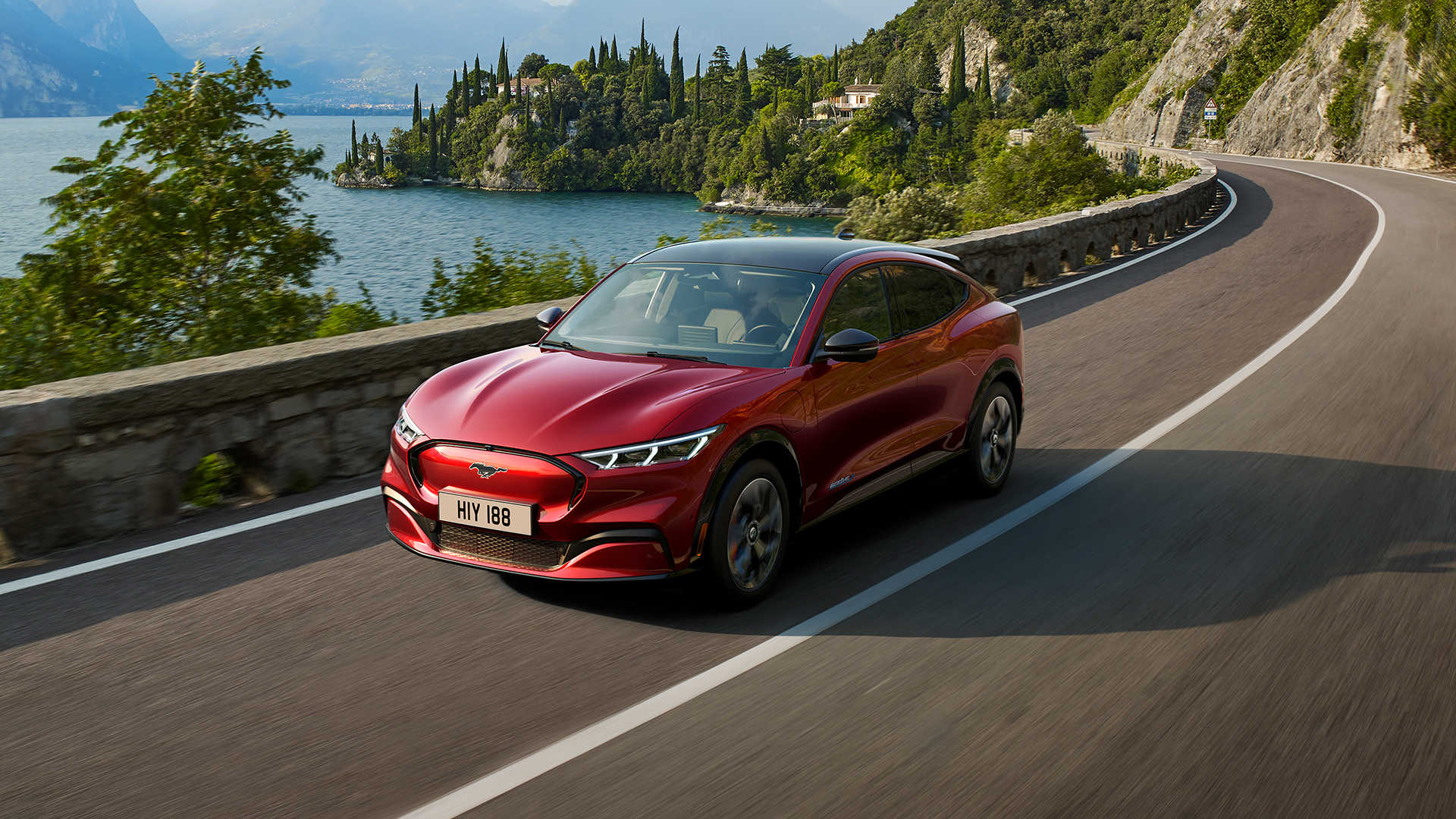 These are the electric cars with the longest range blog image featuring a red electric Ford Mustang MACH-E electric car driving.