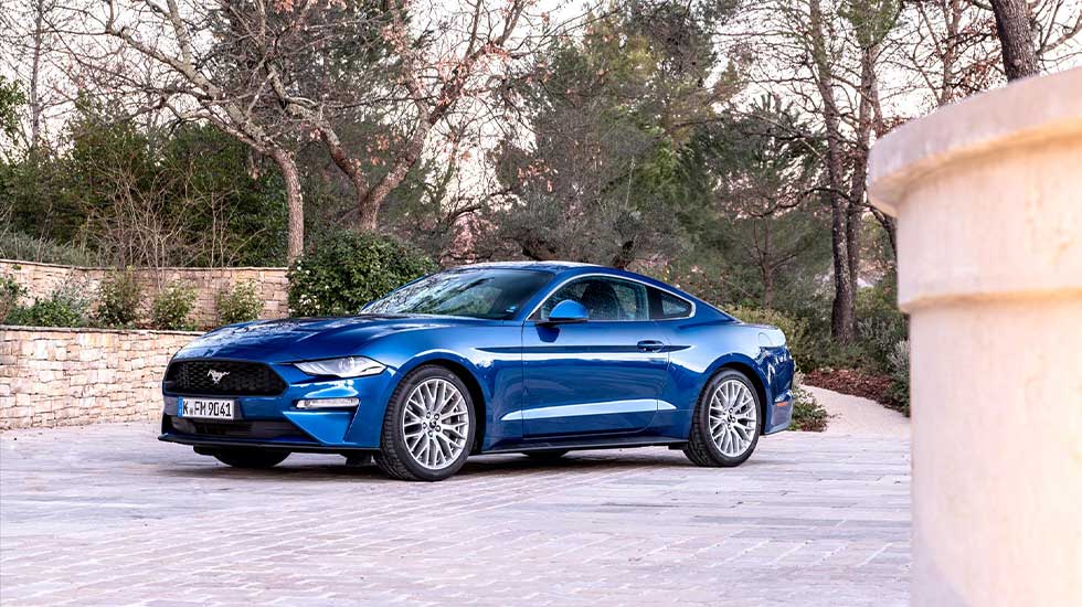 Used Ford Mustang Header image featuring a side on photograph of a blue Ford Mustang parked in a courtyard.