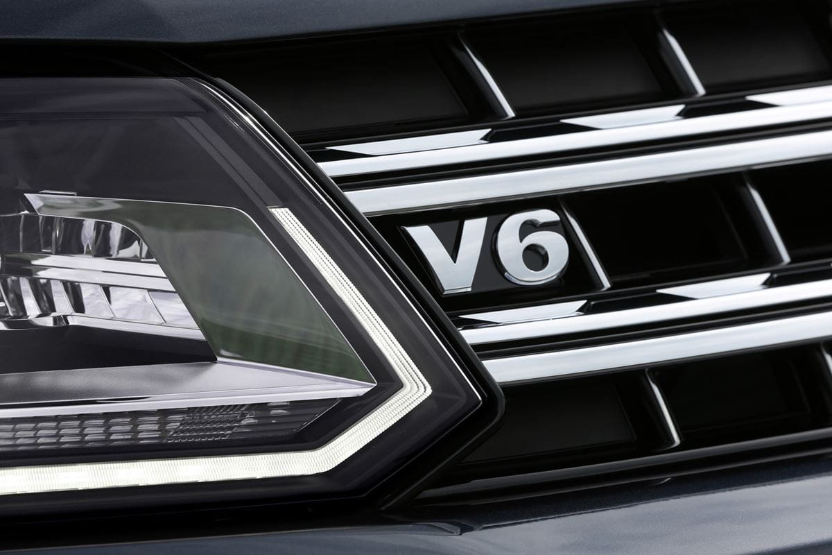 The newer model features a V6 badge on the grille