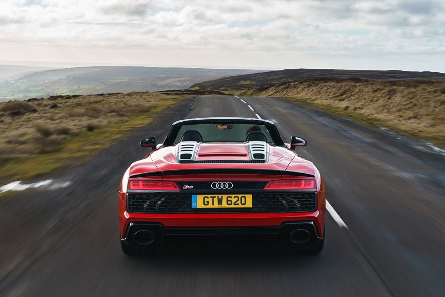 The R8 Spyder's full-width rear grille and oval exhaust tailpipes give it a menacing appearance from behind