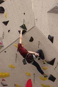 Athlete mid climb up the lead climbing wall at the Lookers National Universities Lead and Speed Climbing Championships