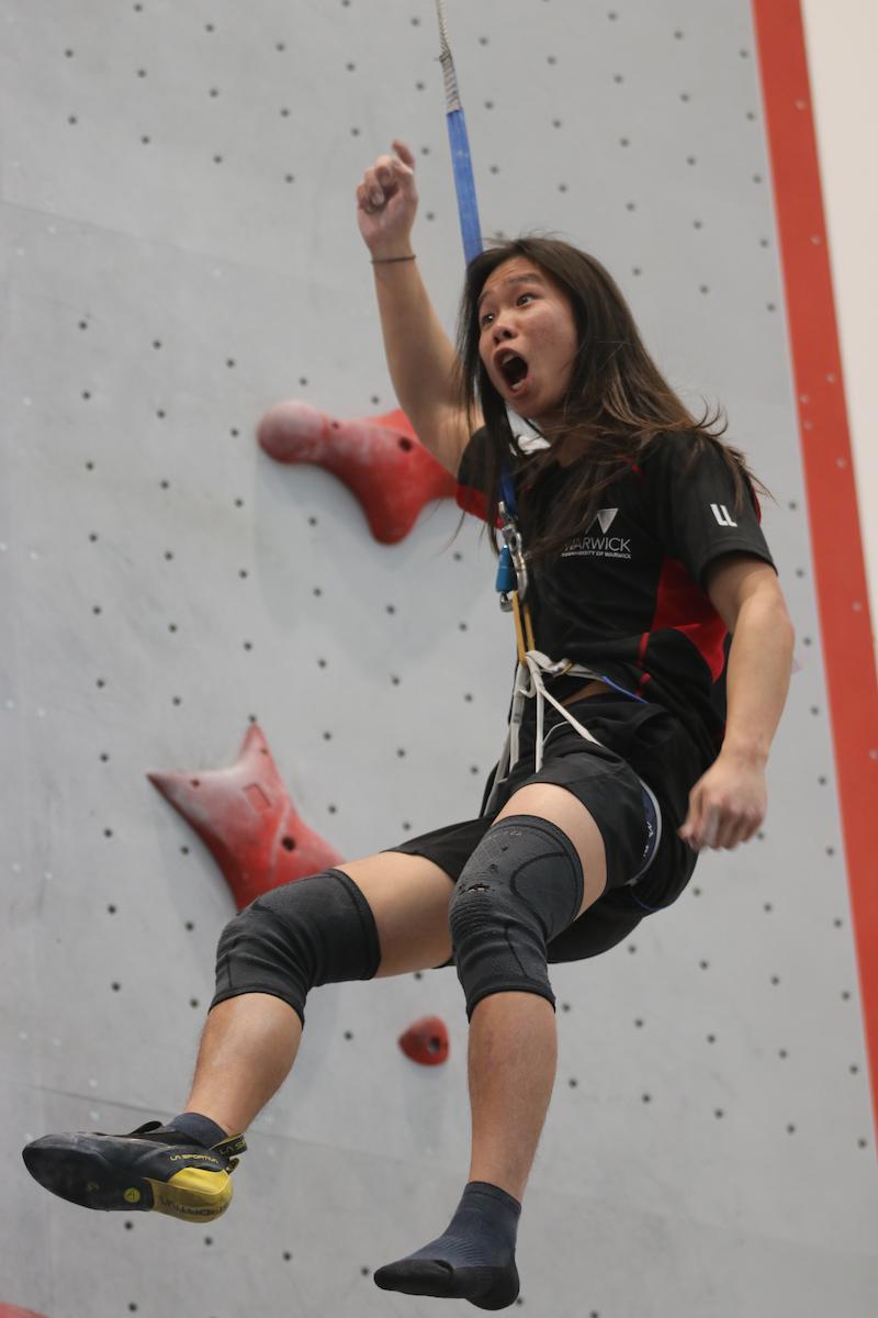Female athlete cheering as she descents the speed climbing wall at the Lookers National Universities Lead and Speed Climbing Championships. 