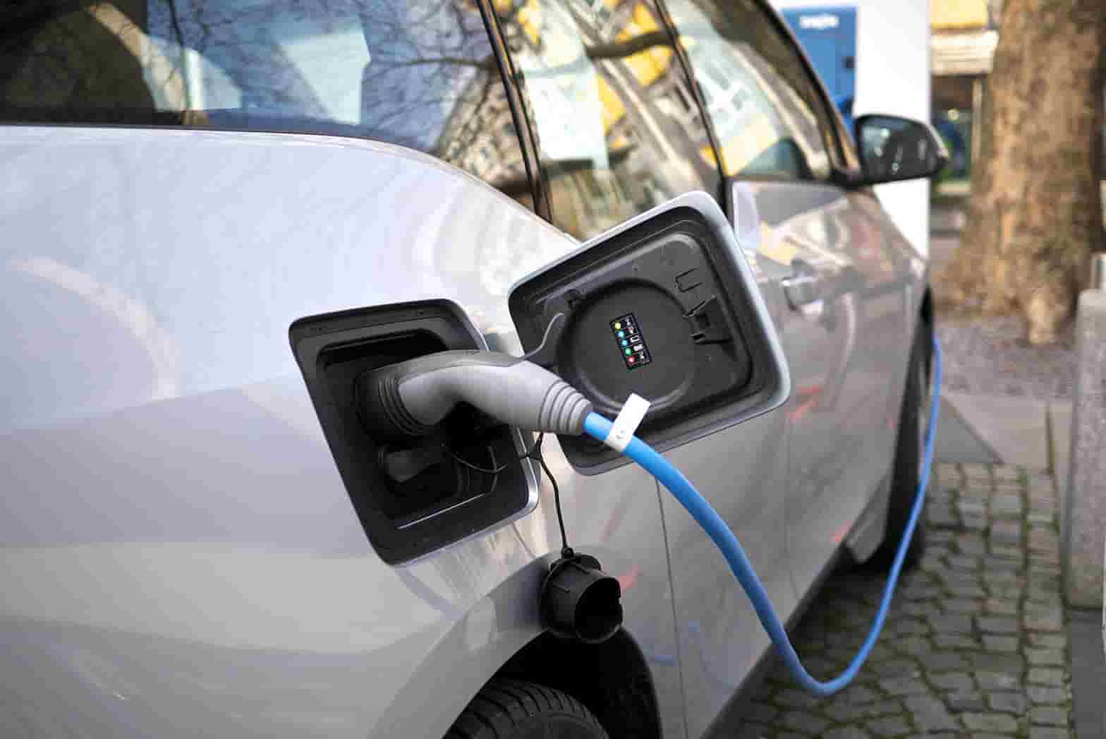 These are the electric cars with the longest range blog card image featuring a timelapse photograph showing electric car lights on a motorway.
