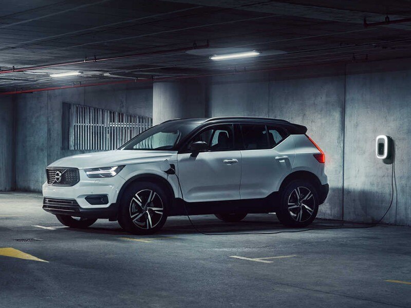 Plug-in Hybrid Electric Vehicle PHEVs image card featuring the side profile of a Plug-in Hybrid Volco XC40 in white parked in an underground car park charging on a public electric car charging point.