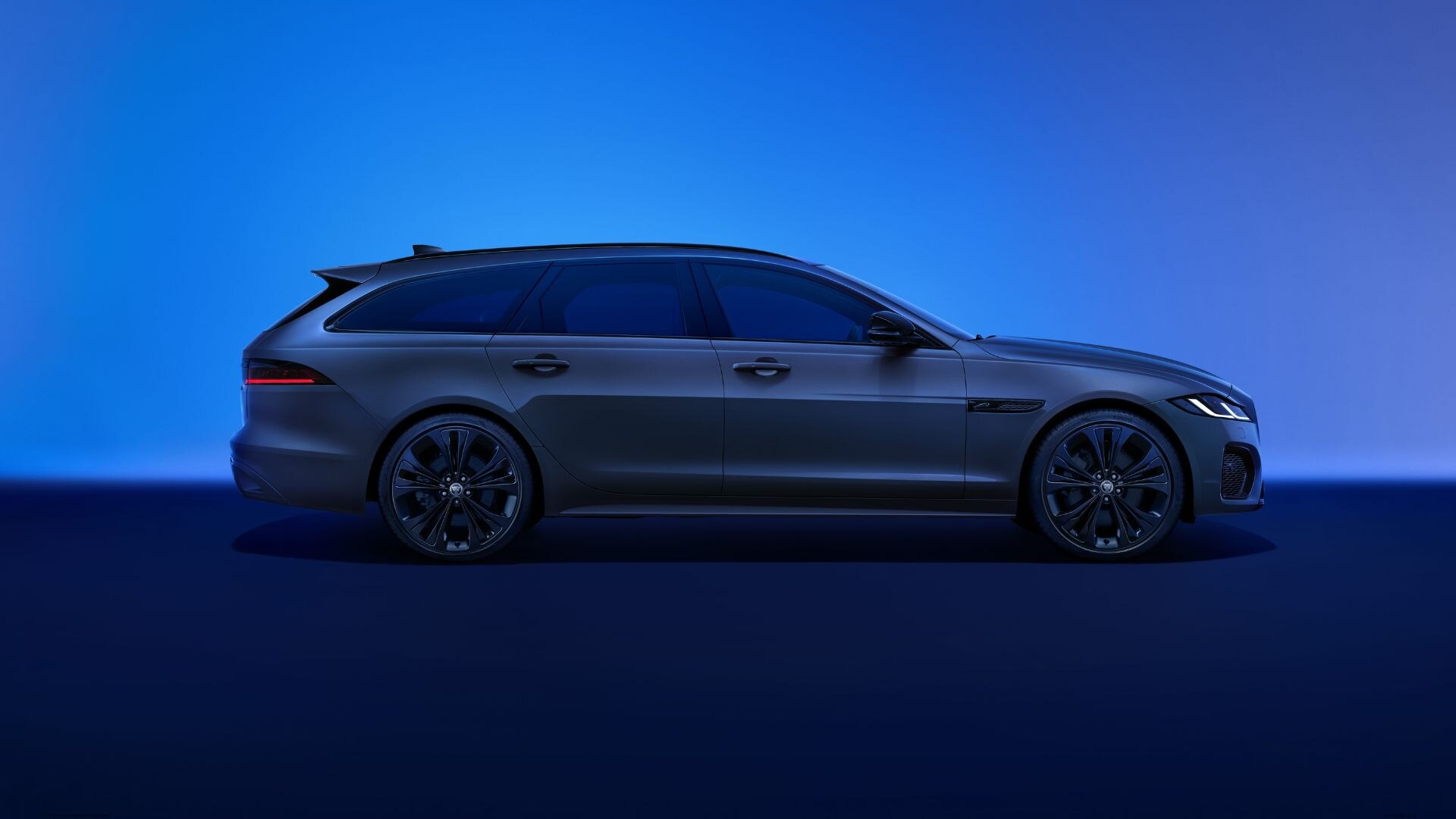 Grey Jaguar XF Sportbrake side on blue background