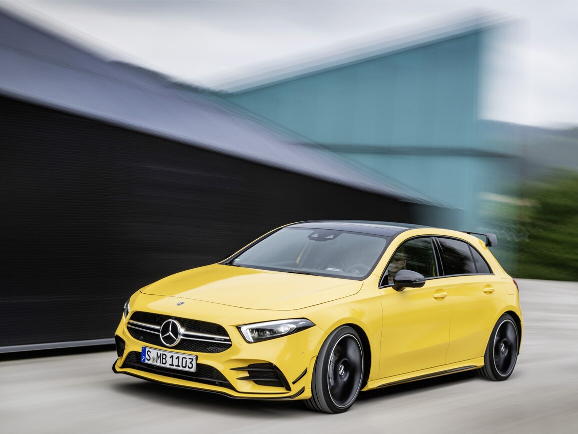 A yellow Mercedes-AMG travelling along the road, standing out against the blurred background