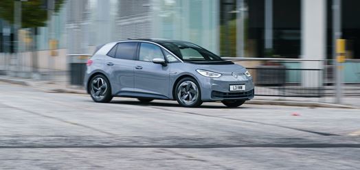 Cheapest Electric Cars on the market right now blog image featuring the electric Volkswagen ID3 in grey. Photograph of the side of the affordable electric car driving outside an office building.