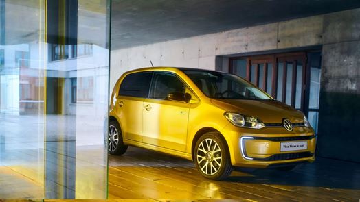 Cheapest Electric Cars on the market Lookers Blog Image featuring the all electric Volkwagen E-up in yellow, one of the most affordable electric cars front shot and rear shot of the vehicle parked on an electric car showroom.